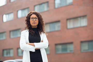 Image showing Beautiful african-american well-dressed businesswoman looks confident and busy, successful