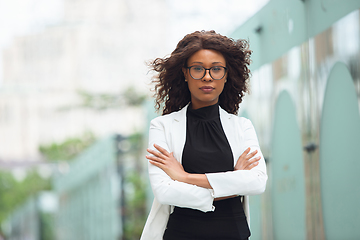 Image showing Beautiful african-american well-dressed businesswoman looks confident and busy, successful