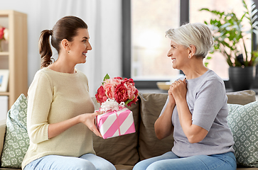 Image showing adult daughter giving present to her senior mother