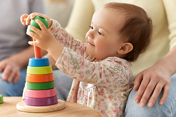 Image showing happy baby girl playing with toy pyramid at home