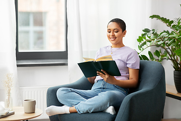 Image showing happy african american woman reading book at home