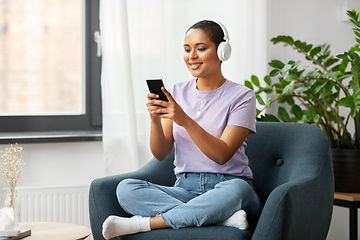 Image showing woman with smartphone listening to music at home