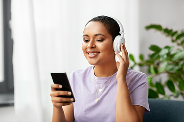 Image showing woman with smartphone listening to music at home