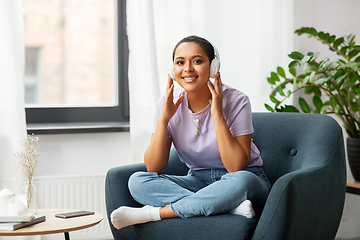 Image showing woman in headphones listening to music at home
