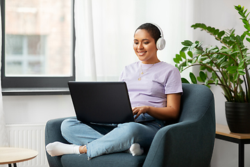 Image showing woman with laptop listening to music at home