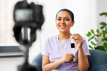 Image showing female blogger with camera video blogging at home