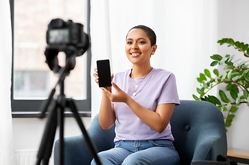 Image showing female blogger with camera video blogging at home