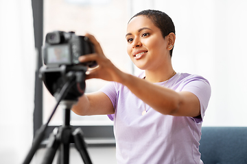 Image showing female video blogger adjusting camera at home