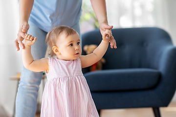 Image showing baby girl learning to walk with mother's help