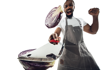 Image showing Amazing african-american man preparing unbelievable food with close up action, details and bright emotions, professional cook. Cutting cabbage on the fly