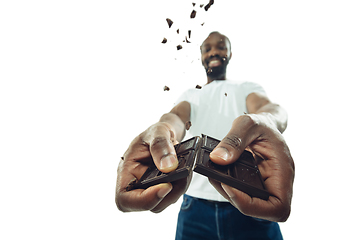 Image showing Amazing african-american man preparing unbelievable food with close up action, details and bright emotions, professional cook. Cracking chocolate