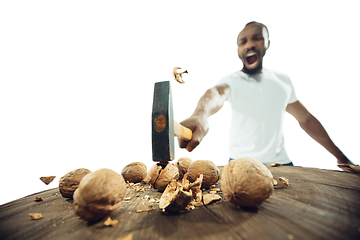 Image showing Amazing african-american man preparing unbelievable food with close up action, details and bright emotions, professional cook. Cracking nuts