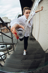 Image showing Close up of woman spilling water from glass, action and motion cought in moment, focus on pure splash