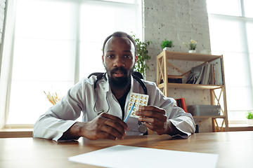 Image showing Doctor advising the patient online with laptop. African-american doctor during his videocall, work with patients, explaining recipes for drug.