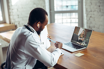 Image showing Doctor advising the patient online with laptop. African-american doctor during his videocall, work with patients, explaining recipes for drug.