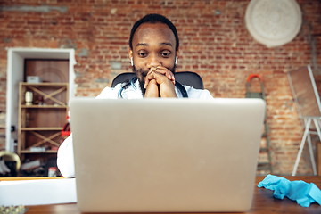 Image showing Doctor advising the patient online with laptop. African-american doctor during his videocall, work with patients, explaining recipes for drug.