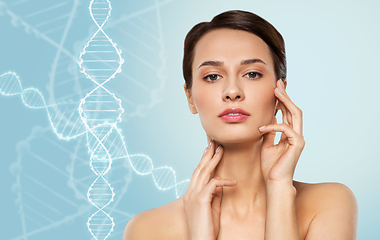 Image showing young woman touching her face over dna molecules