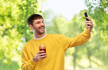 Image showing happy man with smartphone and juice taking selfie