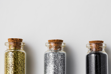 Image showing set of glitters in bottles over white background