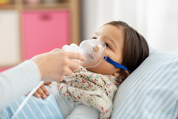 Image showing mother and sick daughter with oxygen mask in bed