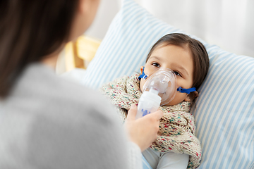 Image showing mother and sick daughter with oxygen mask in bed