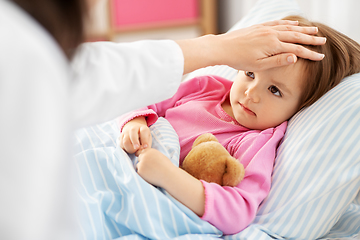 Image showing doctor measuring sick girl's temperature at home