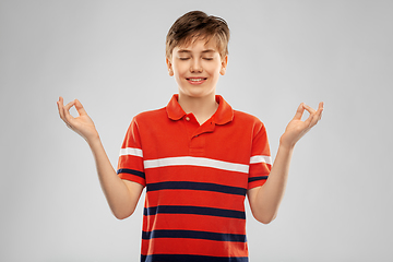 Image showing happy smiling meditating boy in red polo t-shirt