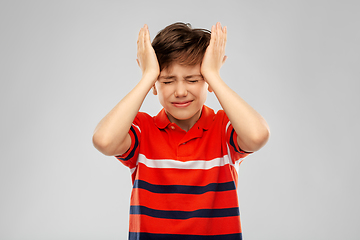 Image showing stressed boy in red polo t-shirt having headache