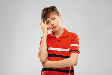 Image showing portrait of sad thinking boy in red polo t-shirt