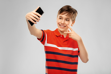 Image showing happy smiling boy taking selfie with smartphone