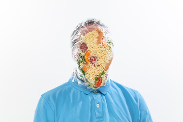 Image showing Male face covered with oilcloth, cellophane and unhealthy food, hard to breathe. People lost their faces, can\'t notice the environmental pollution made by themself.