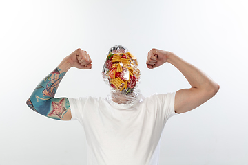 Image showing Male face covered with oilcloth, cellophane and unhealthy food, hard to breathe. People lost their faces, can\'t notice the environmental pollution made by themself.