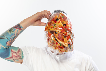 Image showing Male face covered with oilcloth, cellophane and unhealthy food, hard to breathe. People lost their faces, can\'t notice the environmental pollution made by themself.