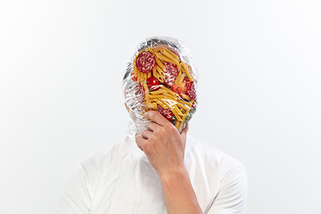 Image showing Male face covered with oilcloth, cellophane and unhealthy food, hard to breathe. People lost their faces, can\'t notice the environmental pollution made by themself.