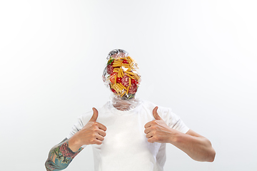 Image showing Male face covered with oilcloth, cellophane and unhealthy food, hard to breathe. People lost their faces, can\'t notice the environmental pollution made by themself.