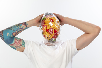 Image showing Male face covered with oilcloth, cellophane and unhealthy food, hard to breathe. People lost their faces, can\'t notice the environmental pollution made by themself.