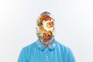 Image showing Male face covered with oilcloth, cellophane and unhealthy food, hard to breathe. People lost their faces, can\'t notice the environmental pollution made by themself.