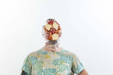 Image showing Male face covered with oilcloth, cellophane and unhealthy food, hard to breathe. People lost their faces, can\'t notice the environmental pollution made by themself.