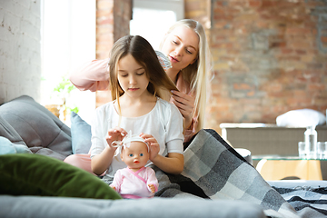 Image showing Mother and daughter, sisters have quite, beauty and fun day together at home. Comfort and togetherness. Making a hairstyle.