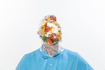 Image showing Male face covered with oilcloth, cellophane and unhealthy food, hard to breathe. People lost their faces, can\'t notice the environmental pollution made by themself.