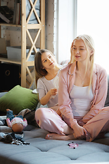 Image showing Mother and daughter, sisters have quite, beauty and fun day together at home. Comfort and togetherness. Making a hairstyle.