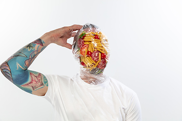 Image showing Male face covered with oilcloth, cellophane and unhealthy food, hard to breathe. People lost their faces, can\'t notice the environmental pollution made by themself.