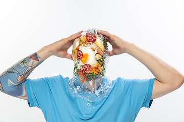 Image showing Male face covered with oilcloth, cellophane and unhealthy food, hard to breathe. People lost their faces, can\'t notice the environmental pollution made by themself.