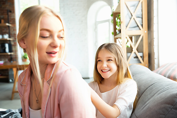 Image showing Mother and daughter, sisters have quite, beauty and fun day together at home. Comfort and togetherness. Making a hairstyle.