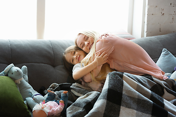 Image showing Mother and daughter, sisters have quite, beauty and fun day together at home. Comfort and togetherness. Hugging, cozy and happy.