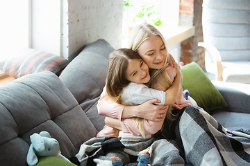 Image showing Mother and daughter, sisters have quite, beauty and fun day together at home. Comfort and togetherness. Hugging, cozy and happy.