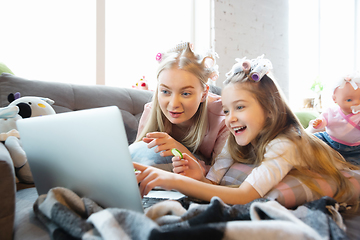 Image showing Mother and daughter, sisters have quite, beauty and fun day together at home. Comfort and togetherness. Watching series, eating healthy food, do a hairstyle