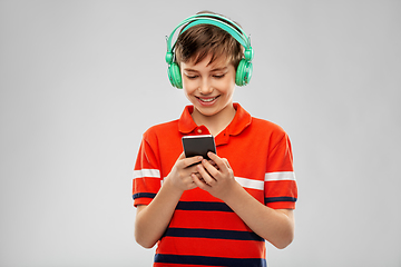 Image showing boy in headphones listening to music on smartphone