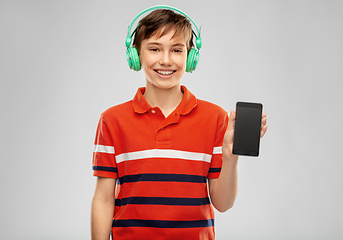 Image showing boy in headphones listening to music on smartphone