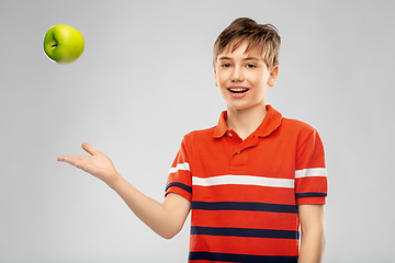 Image showing portrait of happy smiling boy throwing green apple